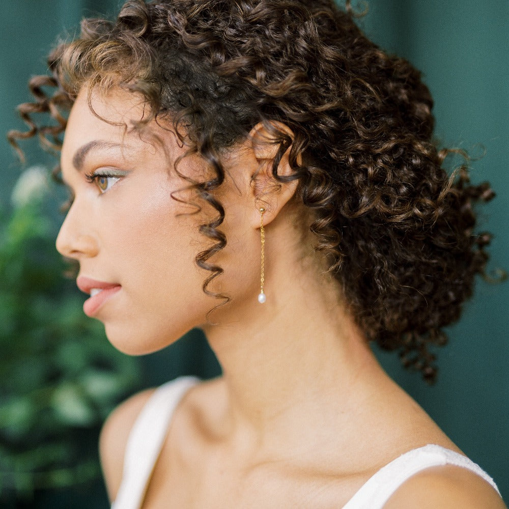 dainty gold chain drop earrings with single small freshwater pearl drop. Earring chain hugs the bottom of the earlobe and wraps around to the back stud. Available in sterling silver, gold filled and rose gold filled. Handmade in Toronto Ontario